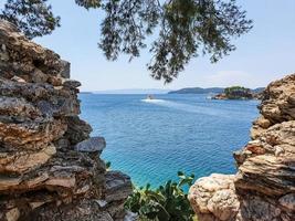 View through ruins of stones to the old part of the town of Skiathos on Skiathos island, Greece. photo