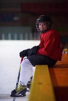 niños jugadores de hockey sobre hielo en un banco foto