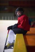 niños jugadores de hockey sobre hielo en un banco foto