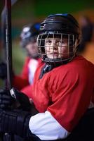 niños jugadores de hockey sobre hielo en un banco foto