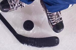 hockey sticsk and puck on ice photo