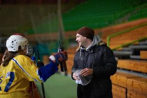 reunión del equipo de jugadores de hockey sobre hielo adolescente con entrenador foto