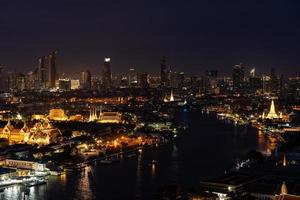 paisaje urbano de bangkok al atardecer con vistas al gran palacio y al río chao phraya desde arriba foto