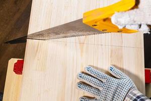 top view of sawing solid wood board with hand saw photo