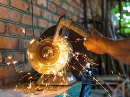 farmer sharpens a hack on electric grindstone photo