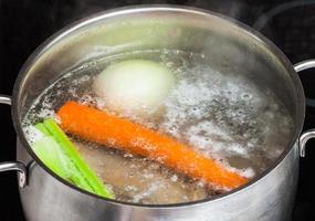 Caldo de carne hirviendo en una cacerola de guiso de cerca foto