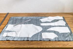 paper layouts of sewing patterns on gray fabric photo