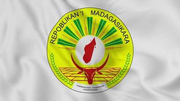 emblema o símbolo nacional de madagascar en la bandera ondeante. bucle suave de video 4k sin problemas