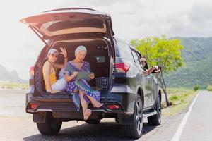 Three best friends enjoying traveling in the car on a road trip. photo