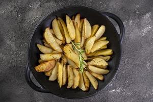 Potatoes baked in iron casserole with rosemary and olive oil