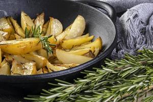 Potatoes baked in iron casserole with rosemary and olive oil