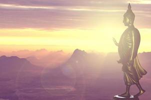 buddha statue at sunrise and mountain background photo