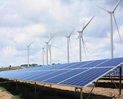 solar panels and wind turbines with the clouds and sky photo