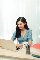 joven jardinera con anteojos usando una laptop, se comunica en internet foto