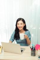 Free Time. Young woman in glasses reading book sitting at home, drinking tea, photo