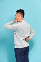 man student feel shoulder pain with blue background, asian photo