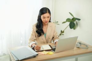 Asian businesswoman mother working at home with notebook computer. Concept for home based work. photo