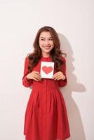 Portrait of happy romantic girl with red paper heart-shaped postcard. photo