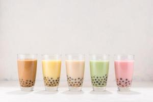 Row of fresh boba bubble tea glasses on white background. photo