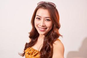 Selfie fun. Happy young women making selfie on camera while standing against beige background photo