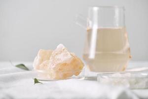 Aromatherapy. Small glass bottles with cosmetic oils. Bath salt. Fresh leaf. Objects for spa procedures on white background oil, leaf. photo