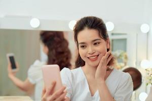 Woman makes selfie in makeup mirror with lamps photo