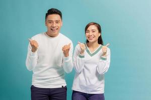 Attractive cheerful young lovers showing thumbs up photo