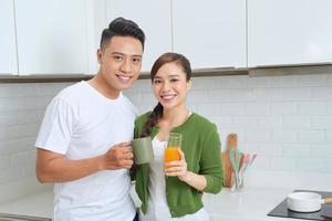 Lovely girl standing on the floor and talking with boyfriend. Young couple enjoying coffee in kitchen. photo