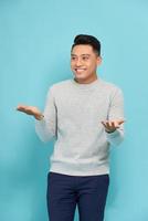 happy young man gesturing and smiling at camera isolated on white photo