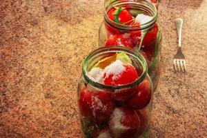 The process of preserving tomatoes for the winter. Ripe red juicy tomatoes in glass jars. photo