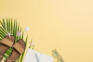 Leather sandals, tropical palm leaves, seashells, starfish on white background. Summer backdrop. photo