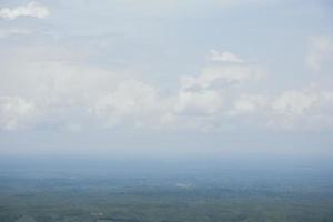 vista aérea del paisaje con un dron de pradera y horizonte de cielo nublado. hermosa vista natural de campos verdes y cielo. tiro de drone de clima brumoso de un área montañosa de la selva y el horizonte del cielo. foto