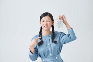 Teenager girl over isolated white background holding vintage alarm clock photo