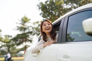 Young tourist woman riding in a taxi in the back seat, and leaning out of windows looks at city. photo