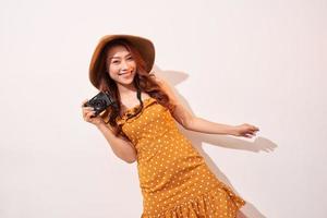 Image of young photographer woman isolated over beige background wall holding camera. photo