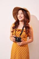 Image of young photographer woman isolated over beige background wall holding camera. photo