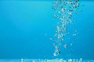 Abstract background image of bubbles in water. Clean water with water droplets and waves. Fresh water a glass with bubbles blue background. photo