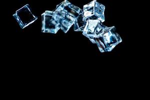 Ice cubes on a black background. ice falling on a black background for use as an illustration in a project photo