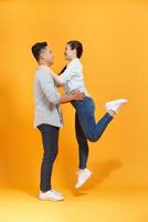 atractiva pareja asiática feliz enamorada divirtiéndose y abrazándose. hombre levantando mujer foto