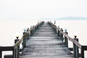 una pasarela de madera que se adentra en el mar. concepto de viaje de vacaciones foto