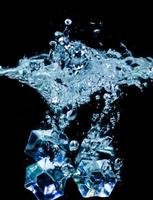 ice cubes in water with bubbles on black background photo