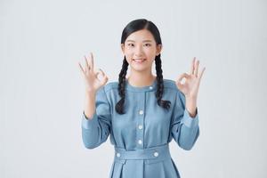 Asian woman show double OK hand sign and smile on white background photo