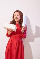 Portrait of a happy smiling girl opening a gift box isolated over white background photo