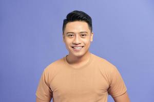 Happy young man. Portrait of handsome young man smiling while standing against color background photo