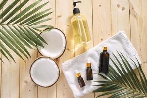 Cracked coconut and a bottle of oil on the table - spa, skincare, haircare and relaxation concept photo