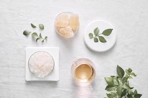 Aromatherapy. Small glass bottles with cosmetic oils. Bath salt. Fresh leaf. Objects for spa procedures on white background oil, leaf. photo