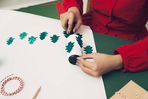 Woman making Christmas paper cover presents. Close up. Xmas concept. photo