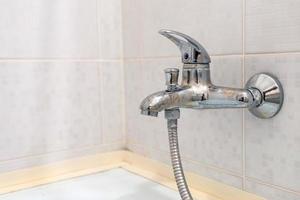 water tap sink with faucet in expensive loft bathroom. detail of a corner shower cabin with wall mount shower attachment photo