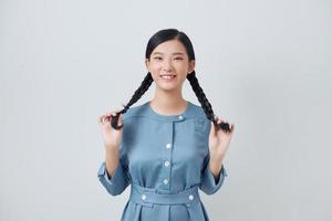 Closeup photo of asian lady plays with two pigtails, isolated bright lilac background, expressing happiness.