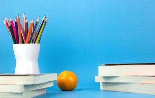 conceptos de regreso a la escuela con libros, bolígrafos, lápices sobre fondo azul claro. utilizado en el cartel de regreso a la escuela, folleto foto